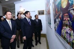 Phó Thủ tướng Vương Đình Huệ (giữa), Tổng Giám đốc Thông tấn xã Việt Nam Nguyễn Đức Lợi (trái) cùng các đại biểu tham quan triển lãm. (Ảnh: Quang Quyết/TTXVN)