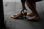 Một nữ nhân viên công sở Philippines thay giày cao gót khi hết giờ làm tại Makati ngày 25/9. (Nguồn: AFP/TTXVN)