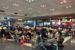 Hành khách ngồi chờ bay tại sân bay Nội Bài sáng 28/7. (Ảnh: PV/Vietnam+)