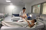 Bác sỹ theo dõi bệnh nhân sau phẫu thuật. (Ảnh: PV/Vietnam+)