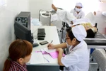 Nhân viên y tế chăm sóc sức khỏe sinh sản cho các thai phụ. (Ảnh: TTXVN)