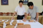 Các nhà nghiên cứu chia sẻ thông tin về những hiện vật được khai quật. (Ảnh: Quốc Dũng/TTXVN)