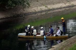 Công nhân đang kiểm tra đoạn sông Tô Lịch nơi đặt máy xử lý ô nhiễm. (Ảnh: Huy Hùng/TTXVN)