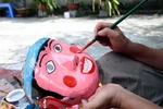 Mặt nạ được những nghệ nhân tỉ mẩn vẽ mô phỏng lại các nhân vật dân gian. (Ảnh: Phạm Kiên/TTXVN)