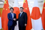 Chủ tịch Trung Quốc Tập Cận Bình (phải) trong cuộc gặp Thủ tướng Nhật Bản Shinzo Abe tại Bắc Kinh ngày 23/12. (Ảnh: AFP/TTXVN)