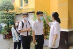 Hơn 75.000 thí sinh Thành phố Hồ Chí Minh đến làm thủ tục dự thi tốt nghiệp THPT đều được đo kiểm tra thân nhiệt. (Ảnh: Xuân Anh/TTXVN)