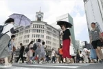 Người dân che ô tránh nắng tại Ginza, thủ đô Tokyo, Nhật Bản ngày 14/7. (Ảnh: Kyodo/TTXVN)