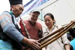 Đôi vợ chồng này hào hứng học cách thổi khèn. (Ảnh: Doãn Đức/Vietnam+)
