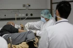Nhân viên y tế điều trị cho bệnh nhân nhiễm COVID-19 tại bệnh viện (Ảnh: THX/TTXVN)