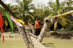Du khách trải nghiệm đi cầu dừa trên vùng sông nước Bến Tre trong Khu du lịch sinh thái Lan Vương, ấp 2, xã Phú Nhuận, thành phố Bến Tre (Bến Tre). (Ảnh: Hồng Đạt/TTXVN)