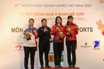 Trao huy chương nội dung 9-Ball Pool nữ (từ trái sang) VĐV Jessica Tan (Singapore, HCB), VĐV Rubilen Amit (Philippines, HCV), VĐV Bùi Xuân Vàng và Nguyễn Bích Trâm (Việt Nam, HCĐ). (Ảnh: Khánh Hoà/TTXVN)