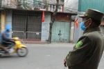 Lực lượng chức năng tiến hành lập chốt tại khu vực có ca nghi nhiễm COVID-19 tại Hà Nội. (Ảnh: Minh Quyết/TTXVN)