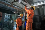 Công nhân Điện lực Châu Đốc (Công ty Điện lực An Giang) sửa chữa và lắp bóng tiết kiệm điện miễn phí cho các hộ nghèo đồng bào dân tộc trên địa bàn huyện Châu Đốc. (Ảnh: Ngọc Hà/TTXVN)