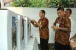 Nhân viên Ủy ban giám sát bầu cử kiểm tra khóa niêm phong hòm phiếu. (Ảnh: Đỗ Quyên/Vietnam+)