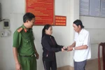 Chị Lê Thị Hậu trao trả lại tài sản cho người đánh rơi tại Công an phường Thanh Bình, thành phố Biên Hòa. (Ảnh: Sỹ Tuyên/TTXVN)