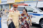 Thiếu tá Đỗ Thành Đạt, Phó Đội trưởng Đội Cảnh sát giao thông đường bộ Phòng Cảnh sát giao thông Công an tỉnh Quảng Ngãi hỗ trợ 3 bà cháu đi bộ trên Quốc lộ 1A từ Quảng Ngãi về Bà Bịa-Vũng Tàu. (Ảnh: TTXVN phát)