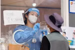 Nhân viên y tế lấy mẫu xét nghiệm COVID-19 cho người dân tại Seoul, Hàn Quốc. (Ảnh: YONHAP/TTXVN)