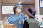 Nhân viên y tế lấy mẫu xét nghiệm COVID-19 cho người dân tại Seoul, Hàn Quốc. (Ảnh: YONHAP/TTXVN)