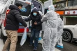 Nhân viên y tế đưa bệnh nhân nhiễm virus corona vào bệnh viện để điều trị tại Hồ Bắc, Trung Quốc. (Ảnh: AFP/TTXVN)