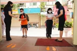Học sinh trường Tiểu học Thăng Long được rửa tay sát khuẩn trước khi vào trường. (Ảnh: Thành Đạt/TTXVN)