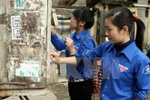 Lực lượng thanh niên đi bóc dỡ quảng cáo rao vặt trái phép. (Nguồn: TTXVN) 