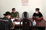 Cơ quan chức năng làm việc với Nguyễn Lập T. (áo đen). )Ảnh: TTXVN phát)