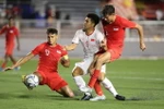 Tiền đạo Đức Chinh bị 2 hậu vệ Singapore kèm sát. (Ảnh: Hoàng Linh/TTXVN)
