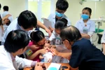 Các giáo sư, bác sỹ khám, điều trị và phẫu thuật miễn phí cho trẻ em bị sứt môi, hở hàm ếch, sẹo xấu ở mũi, khe hở ngang mặt. (Ảnh: Tường Vi/TTXVN)