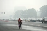 Người dân Trung Quốc đeo khẩu trang để tránh tác hại của khói mù ô nhiễm tại thủ đô Bắc Kinh, Trung Quốc ngày 14/10. (Nguồn: THX/TTXVN)