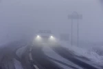 Ôtô di chuyển trên đường trong tuyết và sương mù dày đặc tại Derbyshire, miền Bắc Anh. (Nguồn: AFP/TTXVN) 