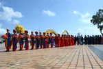 Đoàn rước dâu của đám cưới tập thể đi qua Cầu Rồng. (Ảnh: Quốc Dũng/TTXVN) 