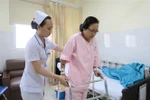 Bệnh nhân Trần Thị Kim Anh (bị gãy chân) đang được hỗ trợ vận động tại Bệnh viện Sài Gòn ITO Phú Nhuận. (Ảnh: Đinh Hằng/TTXVN) 