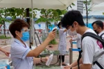 Thí sinh được đo thân nhiệt, sát khuẩn tay trước khi vào điểm thi Trường Trung học cơ sở Phan Chu Trinh, Hà Nội, sáng nay, 8/7. (Ảnh: PV/Vietnam+)
