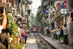 Đoàn tàu Thống Nhất chậm rãi tiến vào Phố đường tàu trong sự phấn khích của du khách. Ai cũng sẵn sàng máy ảnh, điện thoại để lưu lại một khoảnh khắc đáng nhớ. (Ảnh: Trọng Đạt/TTXVN)