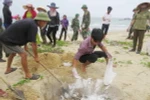 Ngư dân xã biển Đức Trạch (huyện Bố Trạch, Quảng Bình) cùng lực lượng biên phòng thu gom, chôn lấp cá chết dạt vào bờ. (Ảnh: Võ Dung/TTXVN)