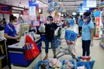 Hội viên Hội Liên hiệp phụ nữ Thành phố Hồ Chí Minh đi chợ giúp người dân mua hàng hóa, lương thực tại siêu thị Co.op Nhiêu Lộc-Thị Nghè. (Ảnh: Thanh Vũ/TTXVN)