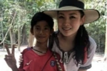 Cậu bé Campuchia chụp ảnh cùng nữ du khách. (Nguồn: nextshark.com)