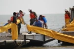 Công nhân đặt rào chắn ngăn dầu loang ở Vịnh Mexico. (Nguồn: AFP/TTXVN)