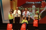 Phó Thủ tướng Trương Hòa Bình trao quà cho học sinh khó khăn. (Ảnh: Phương Vy/TTXVN)