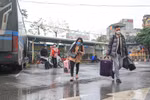 Hành khách xách đồ đạc sau chuyến trở về thành phố mệt nhoài vì ken cứng phương tiện. (Ảnh: Việt Hùng/Vietnam+)