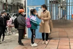 Các trường học bố trí giáo viên trực ban ngay tại cổng để kiểm tra thân nhiệt, nhắc nhở các em học sinh đeo khẩu trang, sát khuẩn tay trước khi vào lớp. (Ảnh: Thanh Vân/TTXVN)