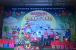 Đại diện Ủy ban Nhân dân xã Nam Phương Tiến tặng quà động viên các em nhỏ khuyết tật. (Ảnh: Nguyễn Cúc/TTXVN) 