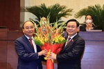 Chủ tịch Quốc hội Vương Đình Huệ chúc mừng Chủ tịch nước Nguyễn Xuân Phúc. (Ảnh: Thống Nhất/TTXVN) 