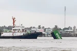 Vụ va chạm hàng hải giữa tàu INTERASIA PURSUIT (quốc tịch Singapore) với sà lan mang biển kiểm soát SG 8259 làm 9 container rỗng bị rơi xuống sông. (Ảnh: TTXVN phát)