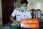 Thành viên Tổ Bầu cử sớm đóng dấu đã bỏ phiếu cho cử tri tại Nhà giàn DK1/17. (Ảnh: TTXVN phát)