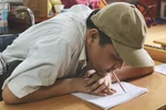 Anh Phùng Văn Trường viết chữ bằng miệng. (Ảnh: PV/Vietnam+)