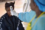 Nhân viên y tế kiểm tra thân nhiệt bệnh nhân nghi nhiễm virus Ebola tại Kenema, Guinea, ngày 16/8/2014. (Ảnh: AFP/TTXVN)