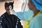 Nhân viên y tế kiểm tra thân nhiệt bệnh nhân nghi nhiễm virus Ebola tại Kenema, Guinea, ngày 16/8/2014. (Ảnh: AFP/TTXVN)