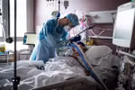 Nhân viên y tế điều trị cho bệnh nhân COVID-19. (Ảnh: AFP/TTXVN)
