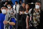 Khách du lịch sử dụng khẩu trang phòng dịch cúm lây lan tại sân bay quốc tế Los Angeles (Mỹ). (Nguồn: AFP/TTXVN)